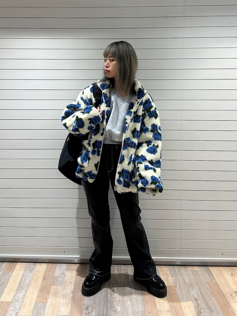 ホワイト系のブルゾン、グレー系のスウェット、ブラック系のその他パンツを着用したレディースの冬コーディネートの4枚目の写真