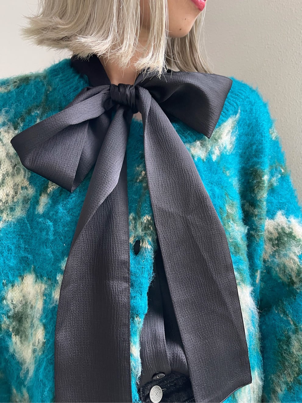 ブラック系のデニムパンツ、ブルー系のカーディガン/ボレロ、ブラック系のシャツ/ブラウスを着用したレディースの秋コーディネートの8枚目の写真