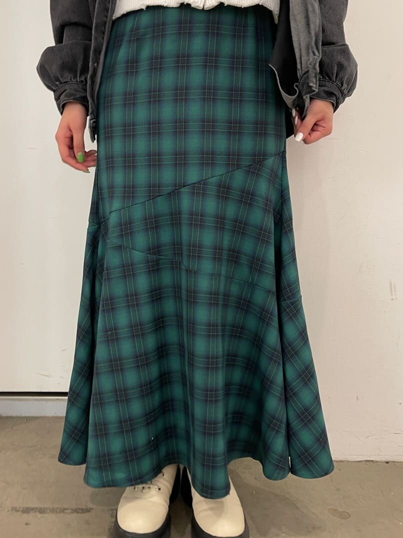 グリーン系のスカート、ブラック系のデニムジャケット、ホワイト系のブーツを着用したレディースの冬コーディネートの7枚目の写真