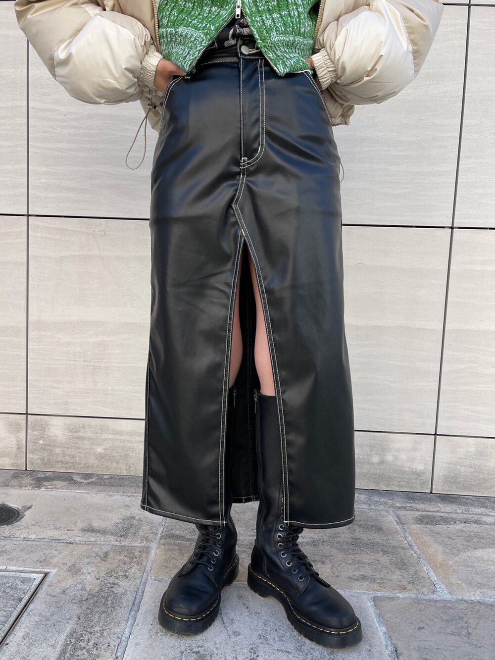 ホワイト系のTシャツ/カットソー、ブラック系のスカート、ブラック系のブーツを着用したレディースの秋コーディネートの8枚目の写真