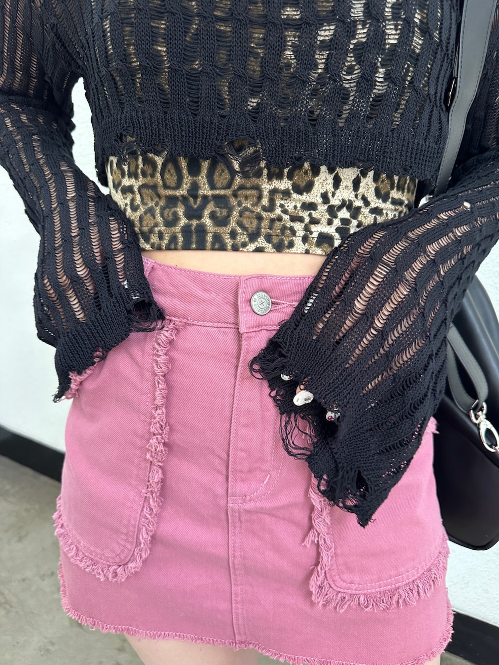 ピンク系のスカート、ブラック系のニット/セーター、ブラウン系のキャミソールを着用したレディースの冬コーディネートの8枚目の写真