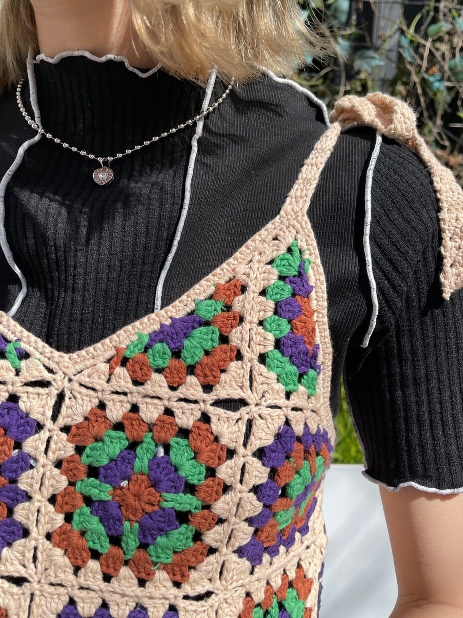 ベージュ系のニット/セーター、ブラック系のTシャツ/カットソー、ブラック系のデニムパンツを着用したレディースの春コーディネートの8枚目の写真