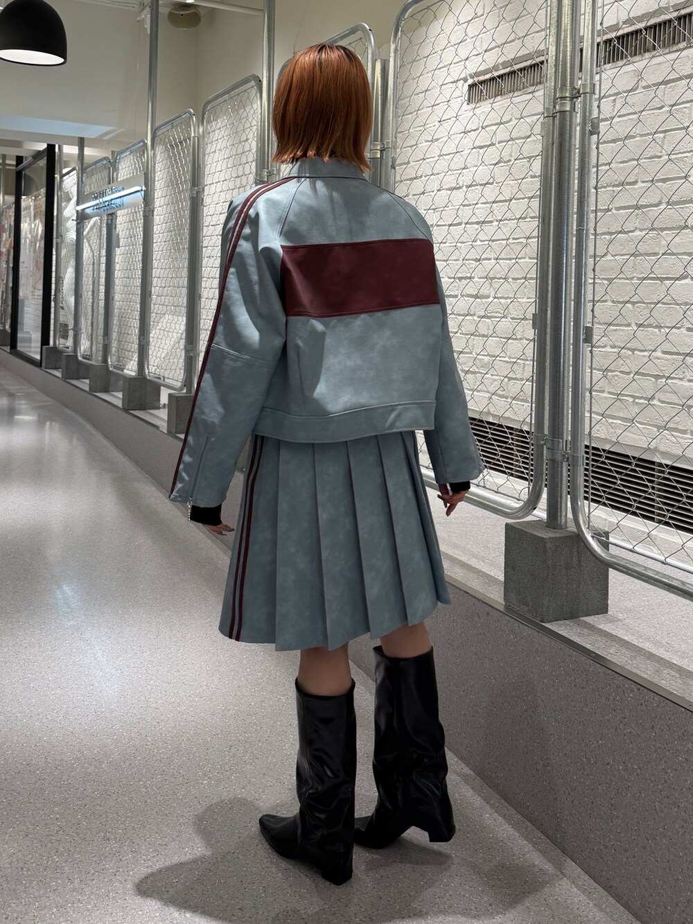 ブルー系のブルゾン、ブルー系のスカート、ブラック系のニット/セーターを着用したレディースの冬コーディネートの3枚目の写真