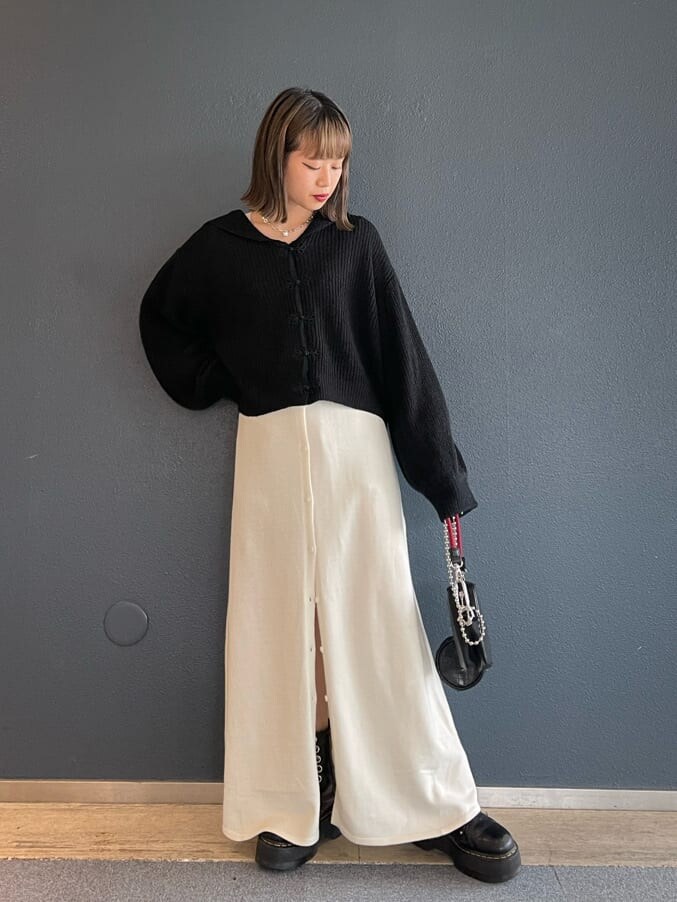 ブラック系のショルダーバッグ、ホワイト系のワンピース、ブラック系のニット/セーターを着用したレディースの秋コーディネートの2枚目の写真