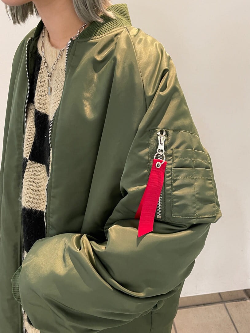 ブラック系のニット/セーター、グリーン系のMA-1、グリーン系のスカートを着用したレディースの秋コーディネートの8枚目の写真