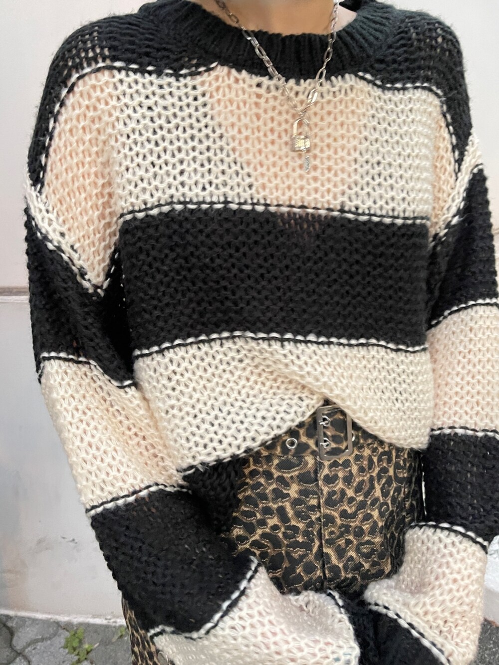 ブラウン系のスカート、ブラック系のニット/セーター、ブラック系のスニーカーを着用したレディースの秋コーディネートの6枚目の写真