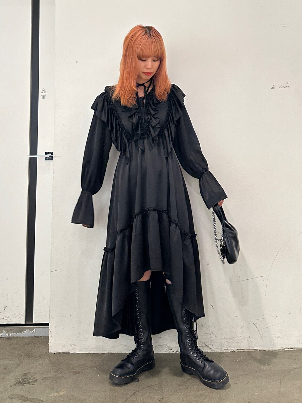 ブラック系のワンピース、ブラック系のハンドバッグ、ブラック系のブーツを着用したレディースの秋コーディネートの6枚目の写真