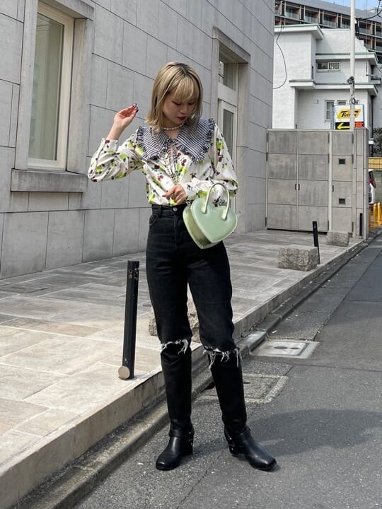 ブラック系のデニムパンツ、ホワイト系のシャツ/ブラウス、グリーン系のショルダーバッグを着用したレディースの春コーディネートの3枚目の写真