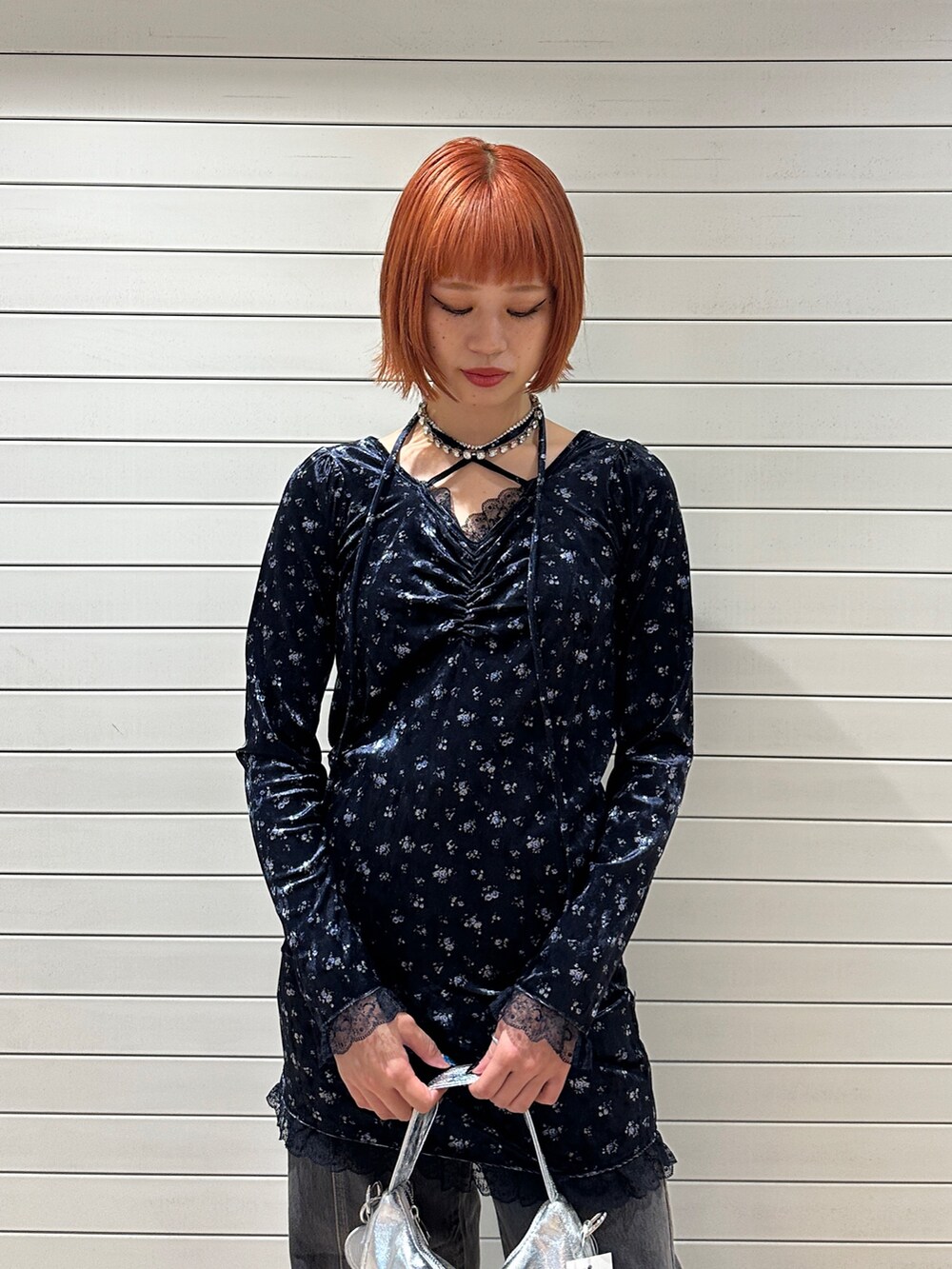 ブルー系のワンピース、シルバー系のハンドバッグ、ブラック系のデニムパンツを着用したレディースの冬コーディネートの6枚目の写真