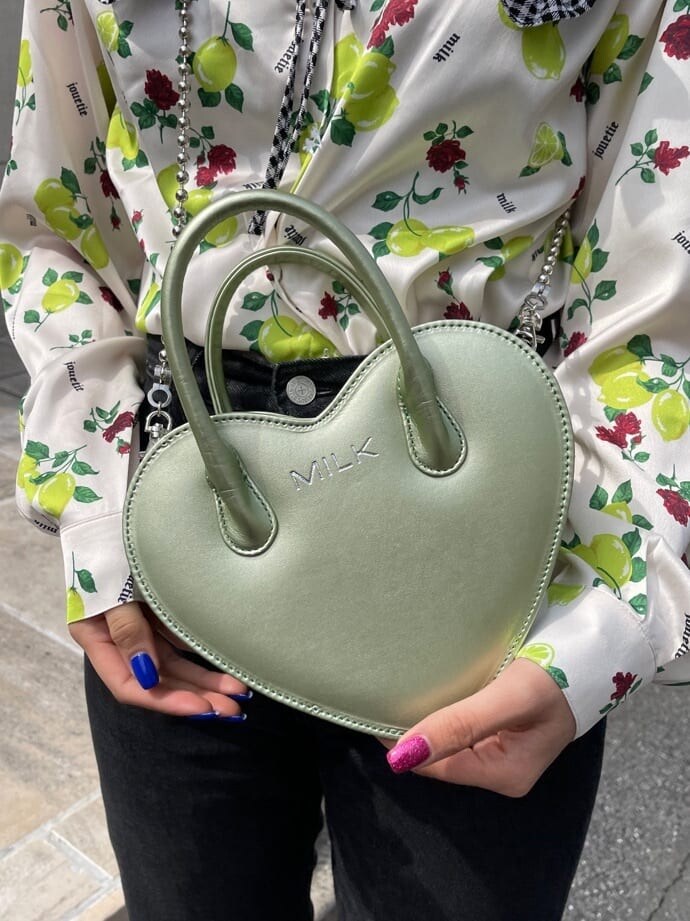 ブラック系のデニムパンツ、ホワイト系のシャツ/ブラウス、グリーン系のショルダーバッグを着用したレディースの春コーディネートの5枚目の写真