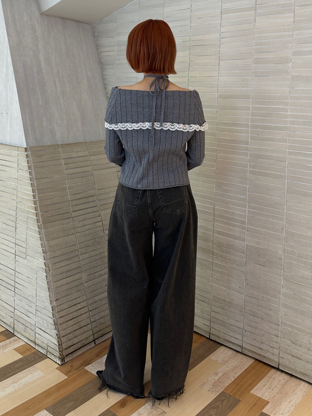 グレー系のニット/セーター、ブラック系のデニムパンツ、ブラック系のブーツを着用したレディースの冬コーディネートの5枚目の写真