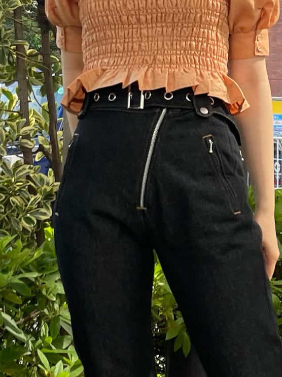 オレンジ系のシャツ/ブラウス、ブラック系のデニムパンツ、ブラック系のハットを着用したレディースの春コーディネートの9枚目の写真