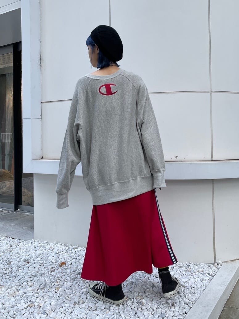 レッド系のスカート、グレー系のスウェット、ブラック系のハンチング/ベレー帽を着用したレディースの秋コーディネートの3枚目の写真