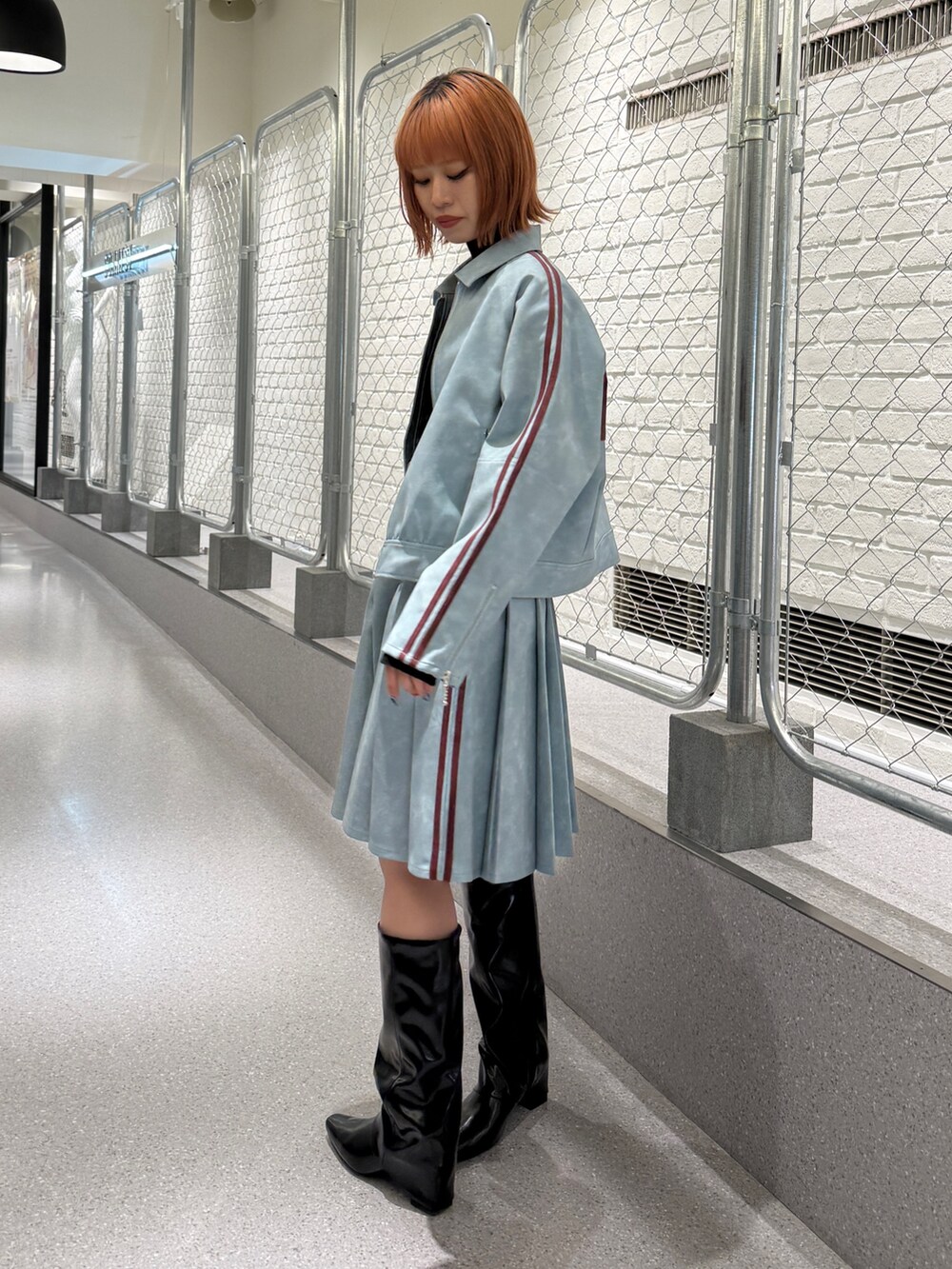 ブルー系のブルゾン、ブルー系のスカート、ブラック系のニット/セーターを着用したレディースの冬コーディネートの4枚目の写真