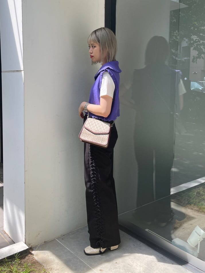 ブラウン系のハンドバッグ、ホワイト系のTシャツ/カットソー、ブラック系のデニムパンツを着用したレディースの夏コーディネートの3枚目の写真