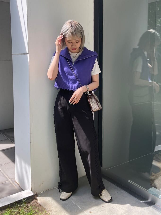 ブラウン系のハンドバッグ、ホワイト系のTシャツ/カットソー、ブラック系のデニムパンツを着用したレディースの夏コーディネートの5枚目の写真