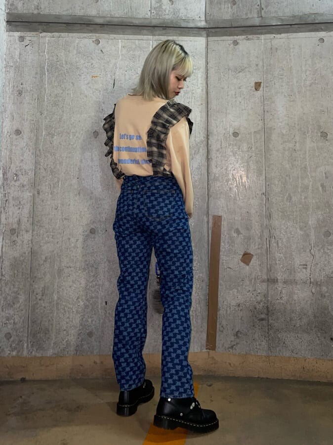 ブラウン系のショルダーバッグ、ベージュ系のTシャツ/カットソー、ブルー系のデニムパンツを着用したレディースの秋コーディネートの3枚目の写真