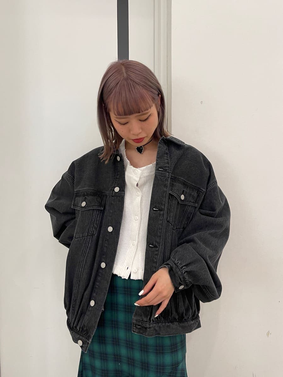 グリーン系のスカート、ブラック系のデニムジャケット、ホワイト系のブーツを着用したレディースの冬コーディネートの4枚目の写真