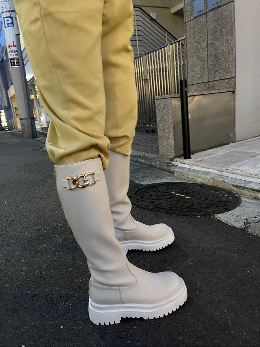 イエロー系のスラックス、ホワイト系のブーツ、ホワイト系のTシャツ/カットソーを着用したレディースの春コーディネートの7枚目の写真