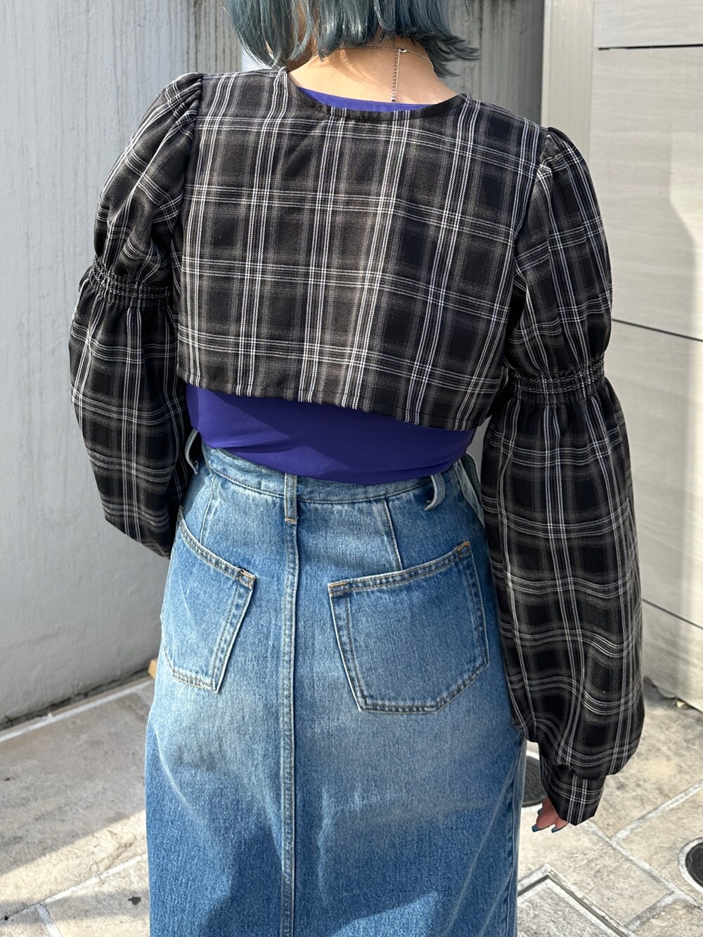 ブルー系のスカート、パープル系のTシャツ/カットソー、ブラック系のワンピースを着用したレディースの冬コーディネートの7枚目の写真