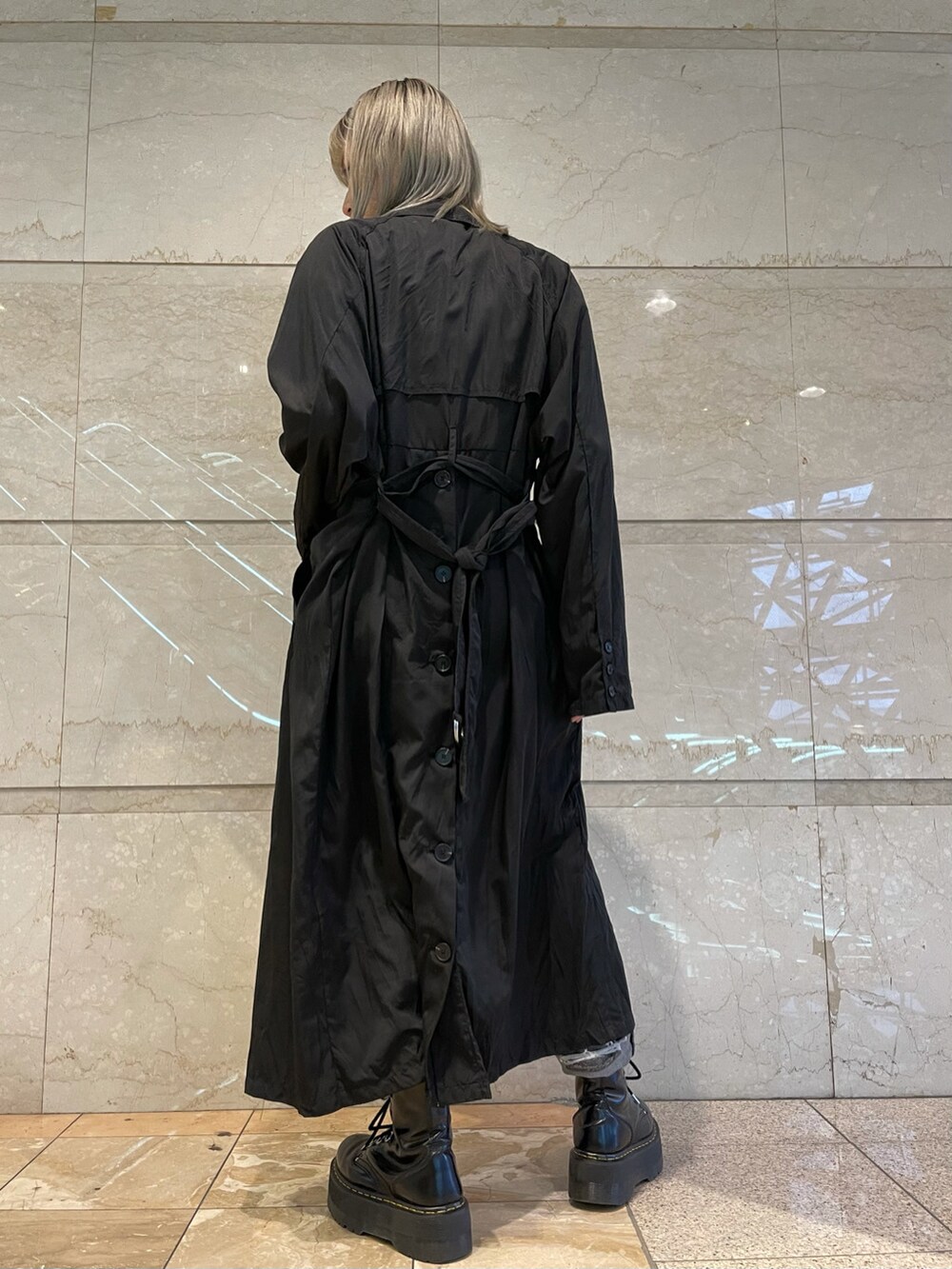 ブラック系のニット/セーター、ブラック系のトレンチコート、ブラック系のデニムパンツを着用したレディースの冬コーディネートの3枚目の写真