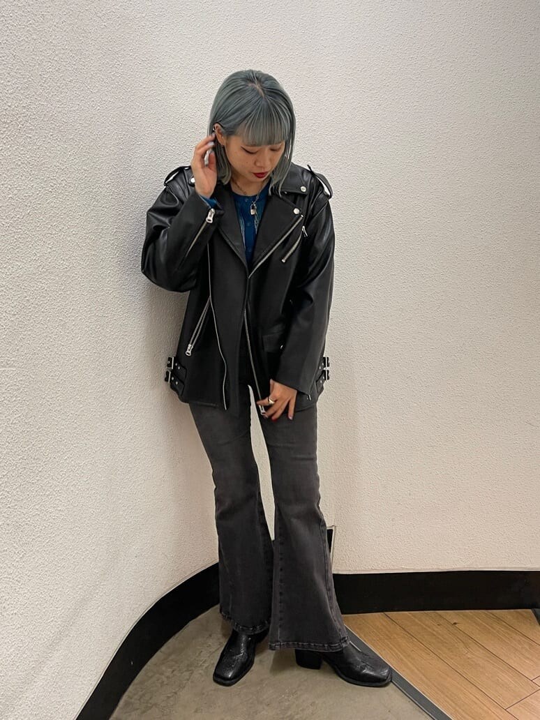 ブラック系のブーツ、ブラック系のライダースジャケット、ブルー系のカーディガン/ボレロを着用したレディースの秋コーディネートの4枚目の写真