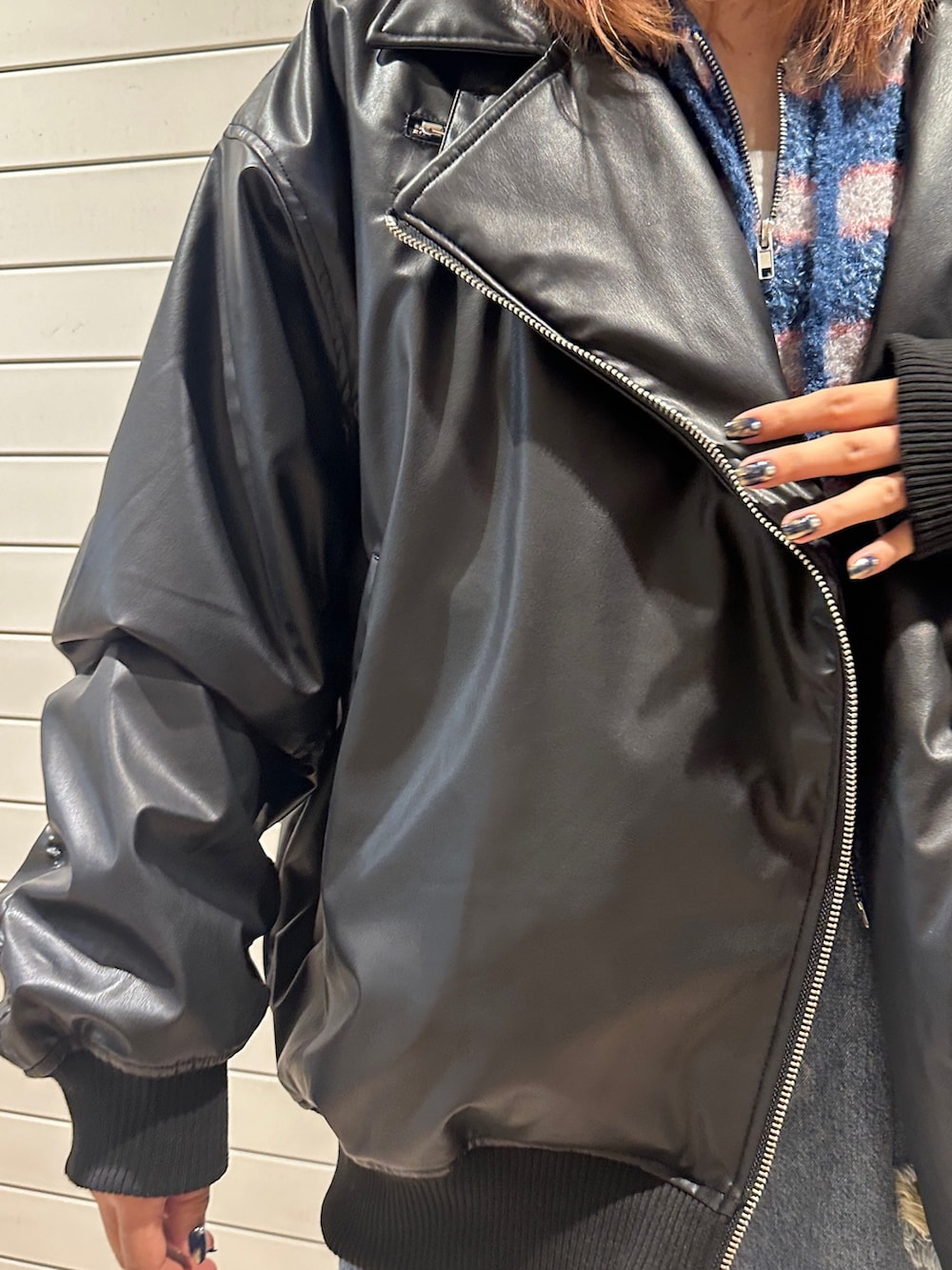 ブラック系のブルゾン、ブルー系のパーカー、ブルー系のデニムパンツを着用したレディースの秋コーディネートの9枚目の写真