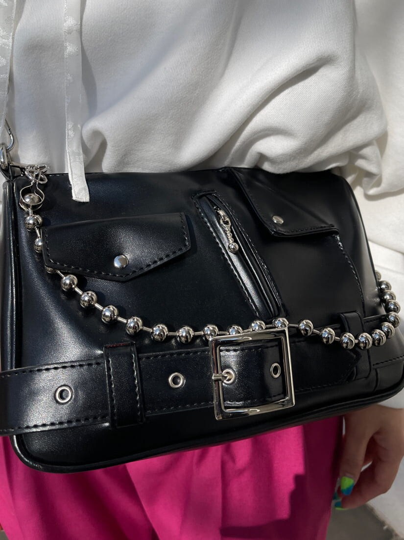 ピンク系のスラックス、ブラック系のショルダーバッグ、ホワイト系のスウェットを着用したレディースの冬コーディネートの8枚目の写真