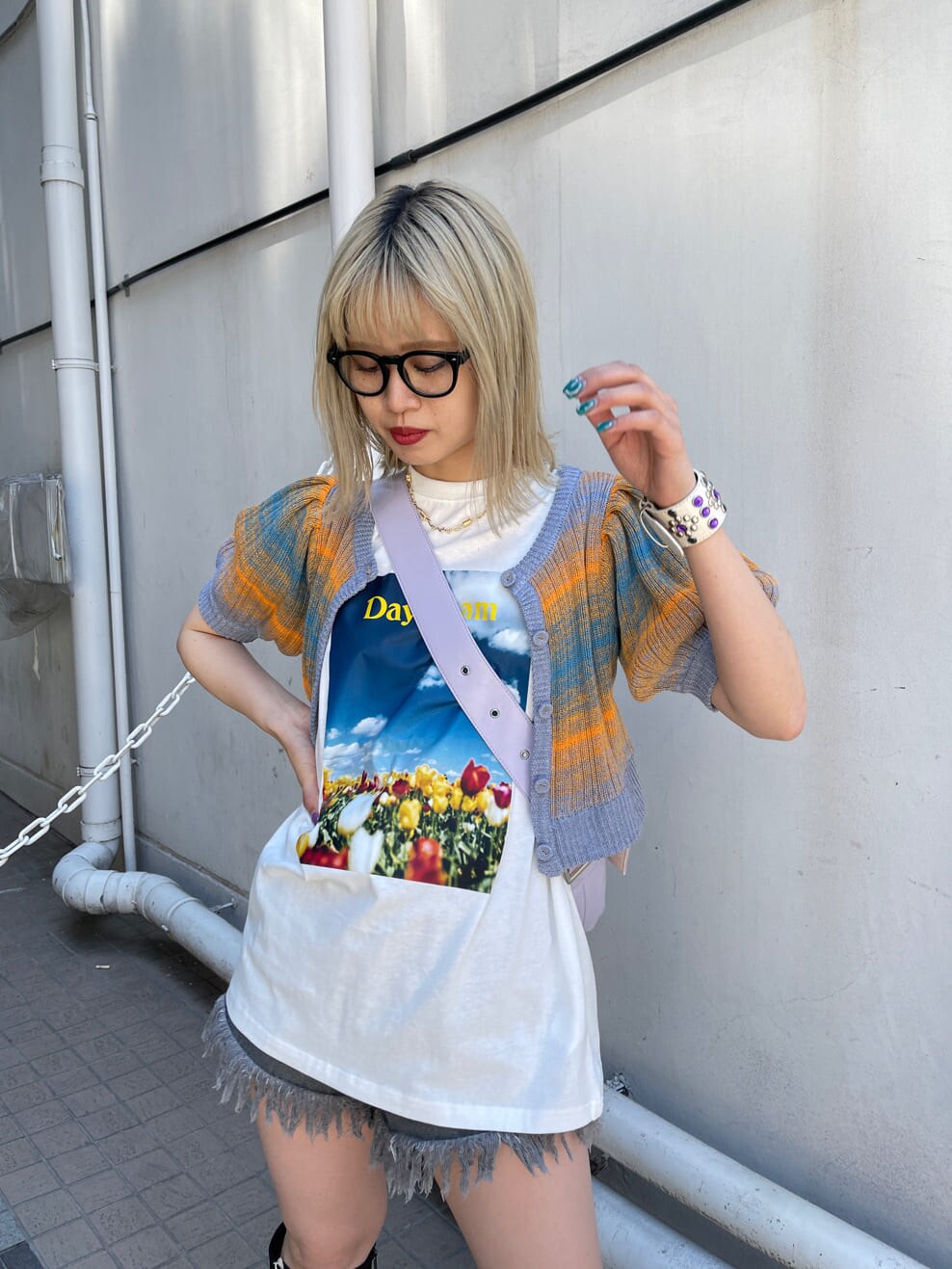 ブラック系のブーツ、ブラック系のデニムパンツ、ホワイト系のTシャツ/カットソーを着用したレディースの春コーディネートの5枚目の写真