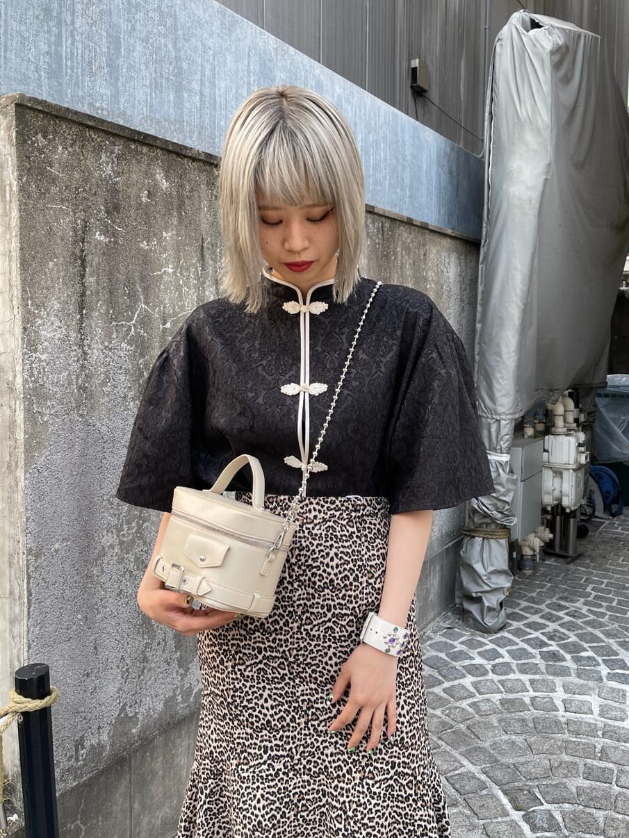 ブラウン系のスカート、ホワイト系のショルダーバッグ、ブラック系のシャツ/ブラウスを着用したレディースの春コーディネートの5枚目の写真