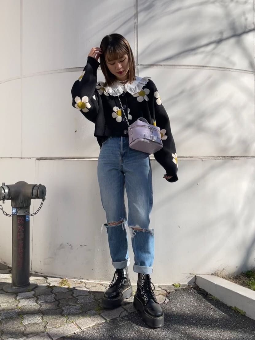 ブルー系のデニムパンツ、ホワイト系のシャツ/ブラウス、パープル系のショルダーバッグを着用したレディースの冬コーディネートの3枚目の写真