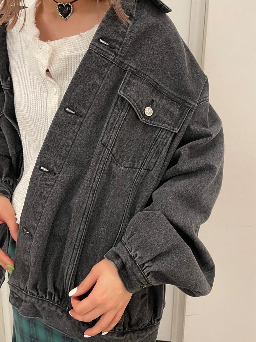 グリーン系のスカート、ブラック系のデニムジャケット、ホワイト系のブーツを着用したレディースの冬コーディネートの6枚目の写真