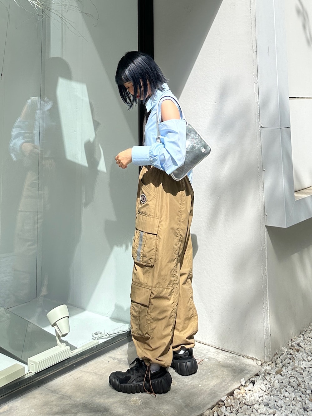 ベージュ系のカーゴパンツ、ブラック系のスニーカー、シルバー系のハンドバッグを着用したレディースの春コーディネートの2枚目の写真