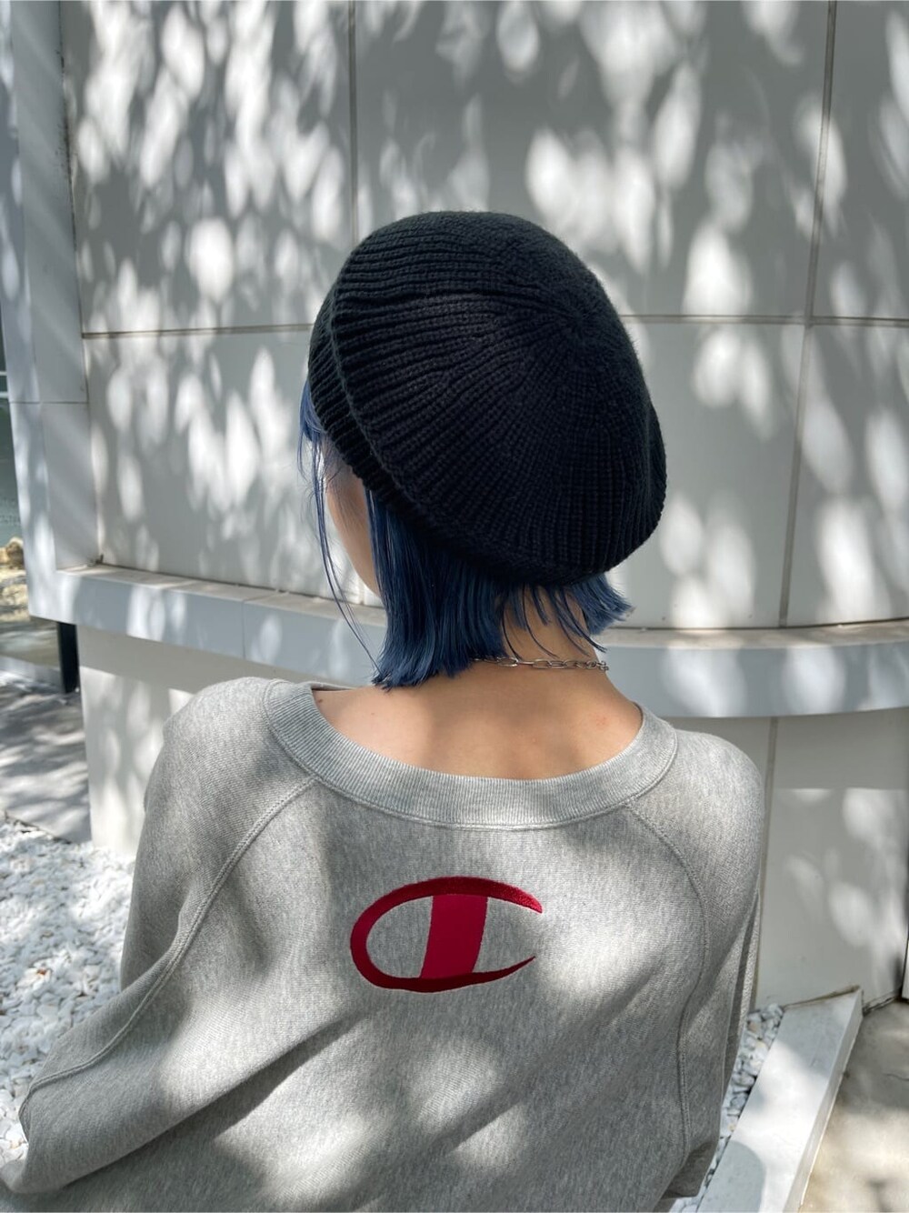 レッド系のスカート、グレー系のスウェット、ブラック系のハンチング/ベレー帽を着用したレディースの秋コーディネートの10枚目の写真