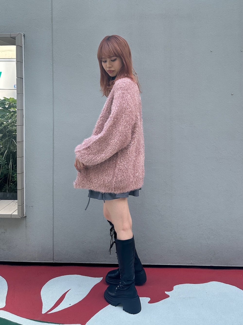 グレー系のスカート、ブラック系のブーツ、ホワイト系のTシャツ/カットソーを着用したレディースの夏コーディネートの2枚目の写真