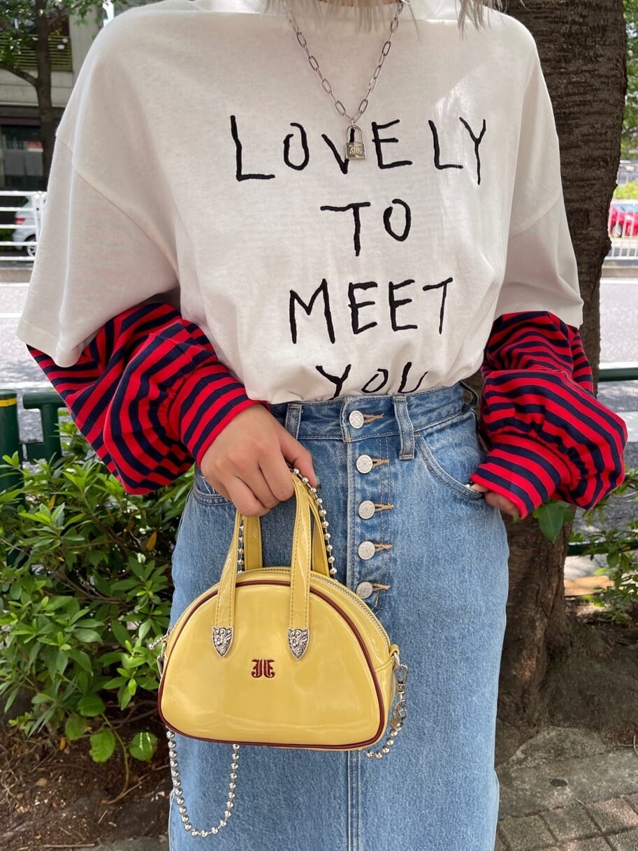 ブラック系のその他シューズ、イエロー系のボストンバッグ、ブルー系のデニムスカートを着用したレディースの夏コーディネートの8枚目の写真