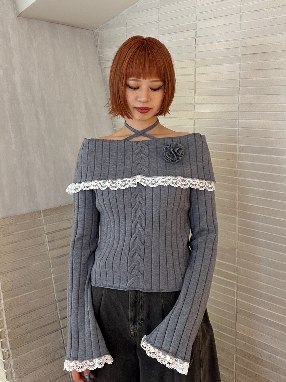 グレー系のニット/セーター、ブラック系のデニムパンツ、ブラック系のブーツを着用したレディースの冬コーディネートの6枚目の写真