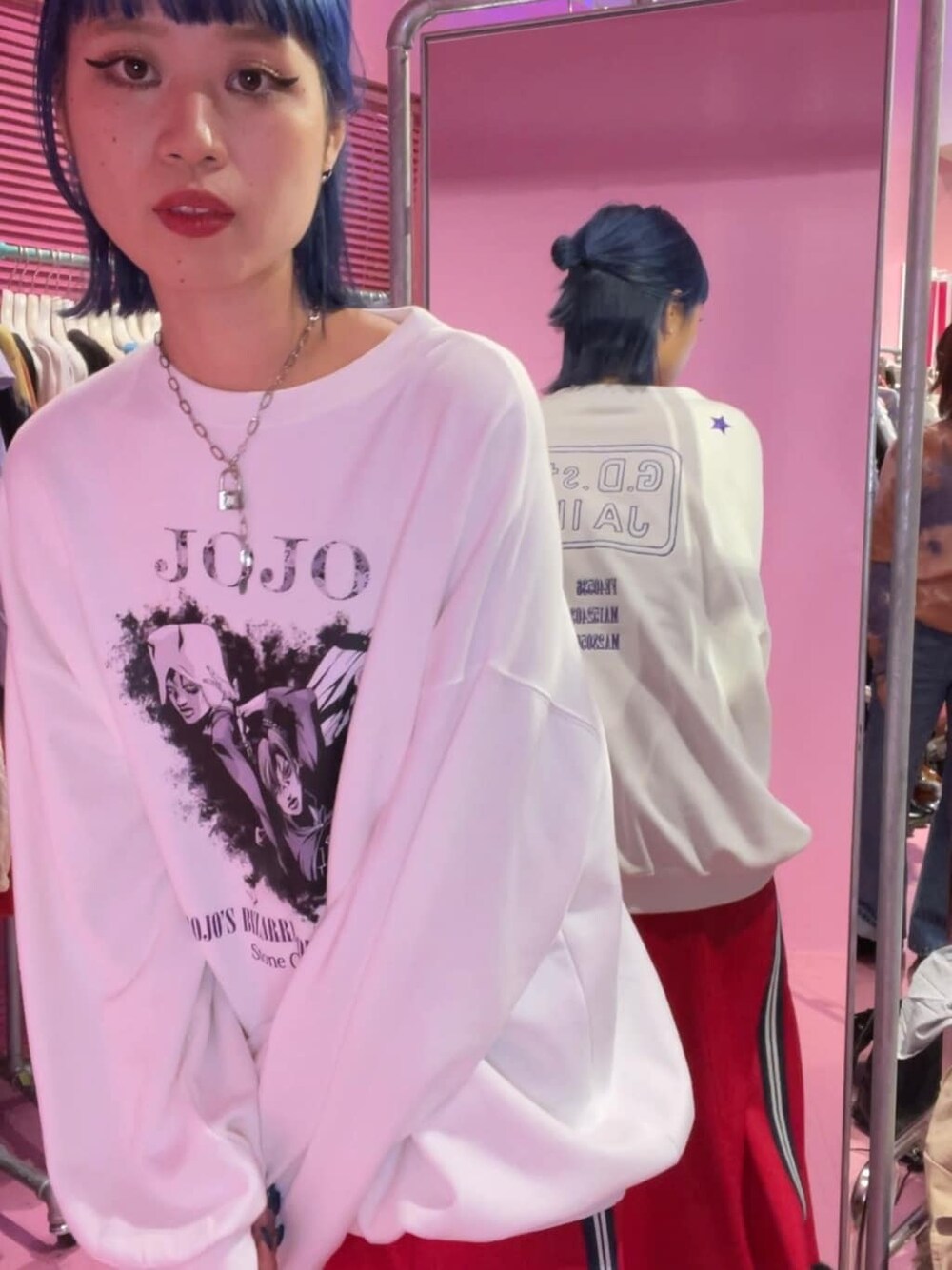 レッド系のスカート、ホワイト系のスウェットを着用したレディースの秋コーディネートの2枚目の写真