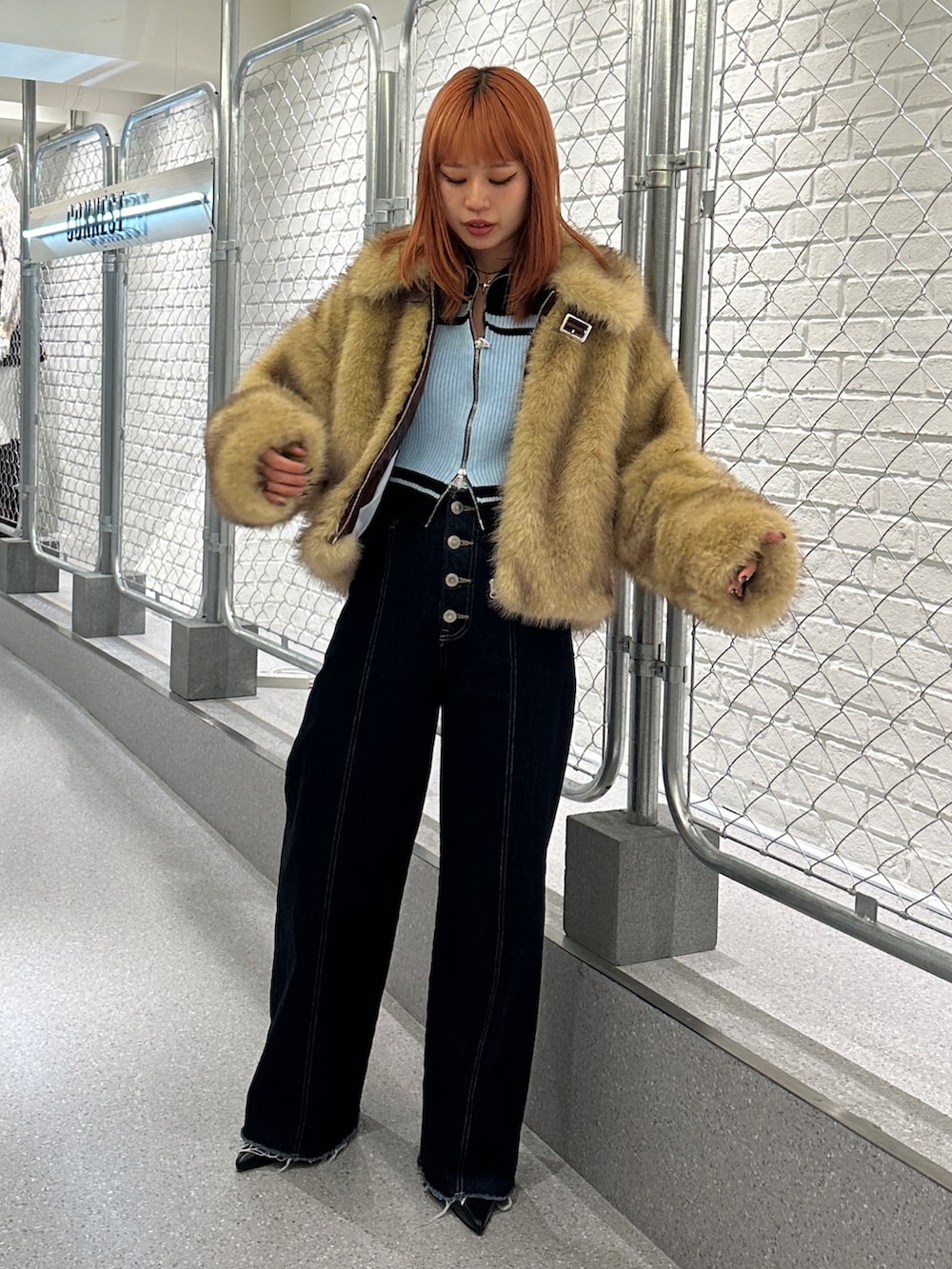 ブルー系のデニムパンツ、ブラック系のパンプス、ブラック系のニット/セーターを着用したレディースの秋コーディネートの4枚目の写真