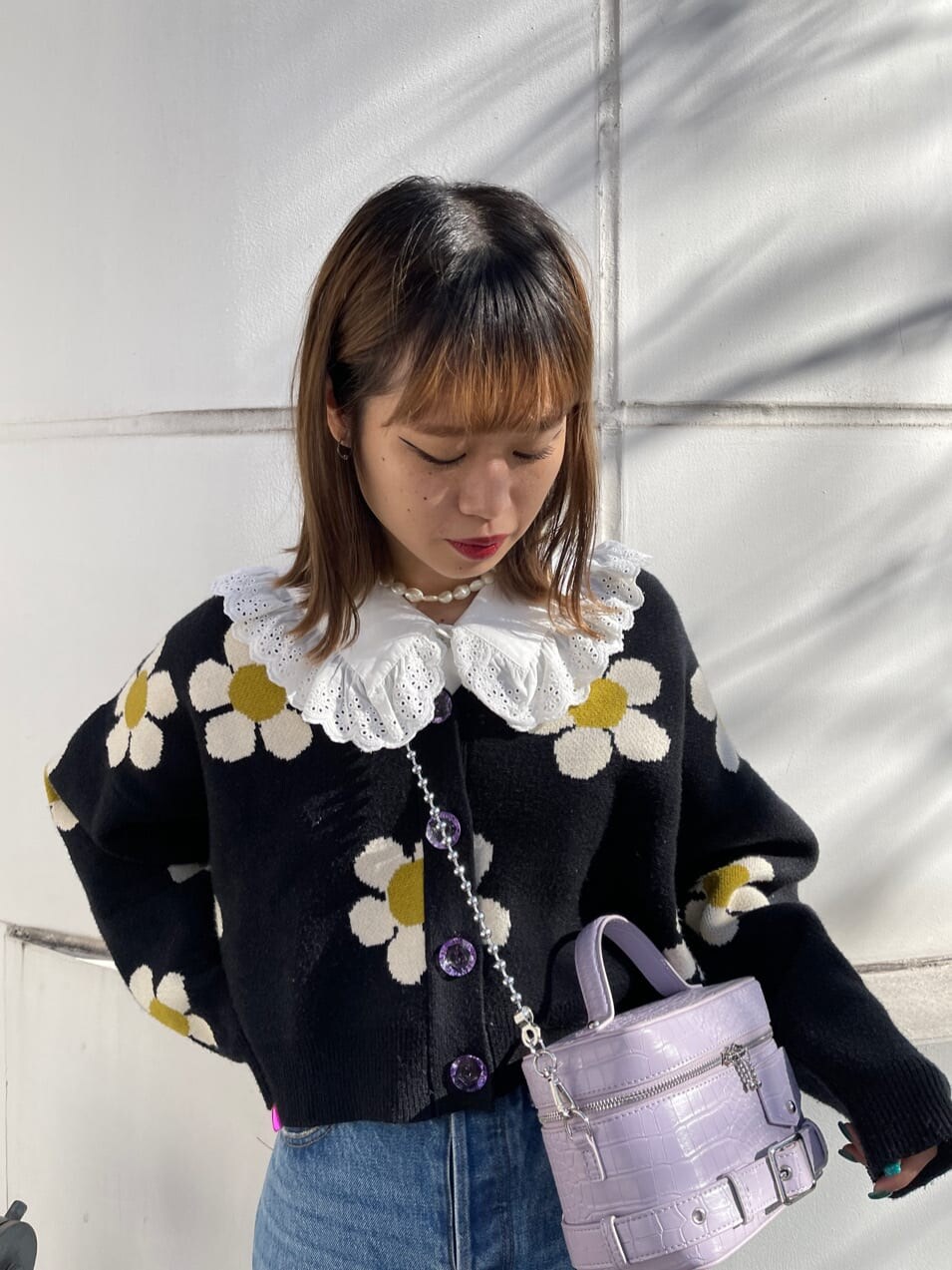 ブルー系のデニムパンツ、ホワイト系のシャツ/ブラウス、パープル系のショルダーバッグを着用したレディースの冬コーディネートの6枚目の写真