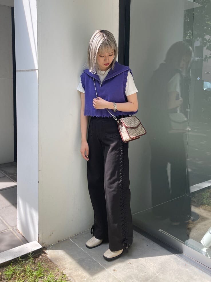 ブラウン系のハンドバッグ、ホワイト系のTシャツ/カットソー、ブラック系のデニムパンツを着用したレディースの夏コーディネートの2枚目の写真