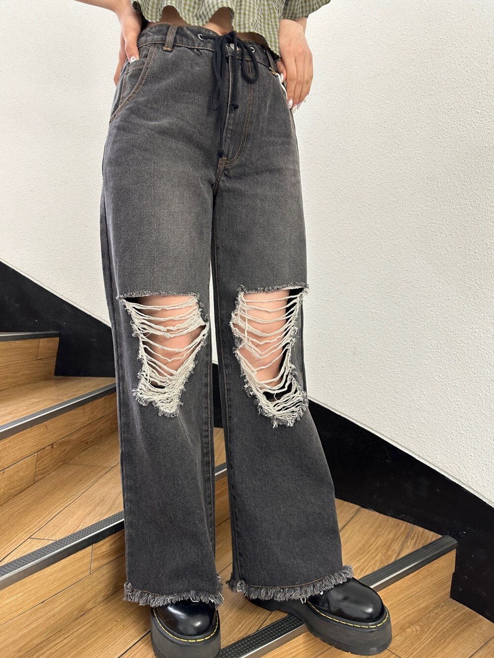 ブラック系のデニムパンツ、グリーン系のシャツ/ブラウス、ブラック系のブーツを着用したレディースの冬コーディネートの9枚目の写真