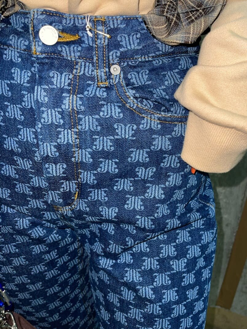 ブラウン系のショルダーバッグ、ベージュ系のTシャツ/カットソー、ブルー系のデニムパンツを着用したレディースの秋コーディネートの7枚目の写真