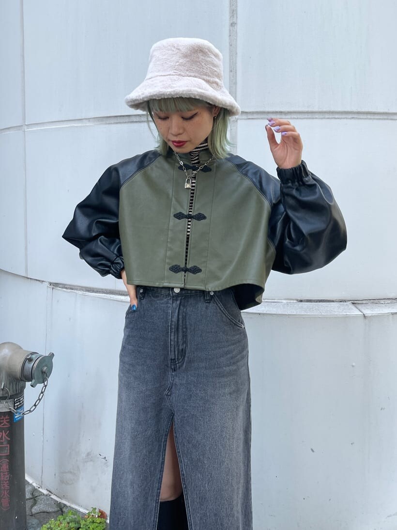 ブラック系のブーツ、ブラック系のスカート、ホワイト系のニット/セーターを着用したレディースの秋コーディネートの3枚目の写真