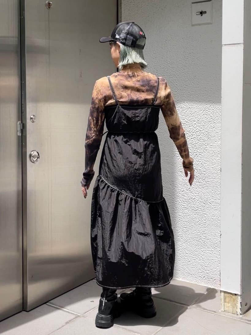 ブラック系のTシャツ/カットソー、ブラック系のジャンパースカート、ブラック系のキャップを着用したレディースの秋コーディネートの3枚目の写真