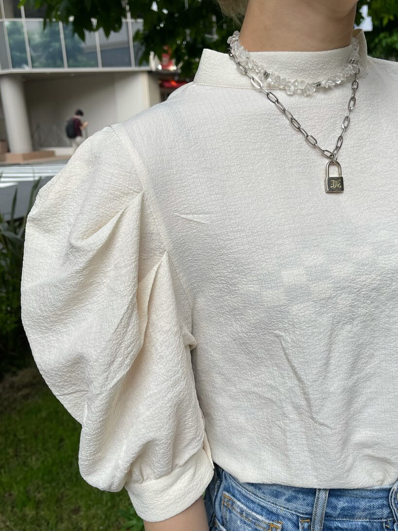 パープル系のショルダーバッグ、ホワイト系のシャツ/ブラウス、ブルー系のデニムパンツを着用したレディースの夏コーディネートの6枚目の写真