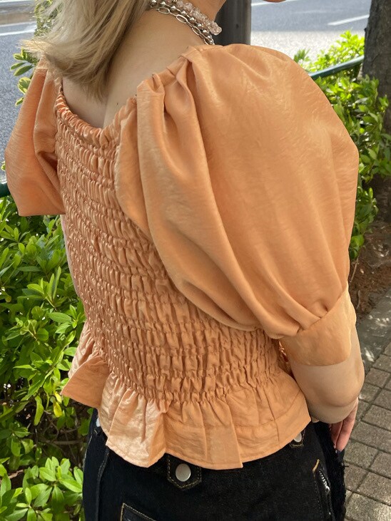 オレンジ系のシャツ/ブラウス、ブラック系のデニムパンツ、ブラック系のハットを着用したレディースの春コーディネートの7枚目の写真