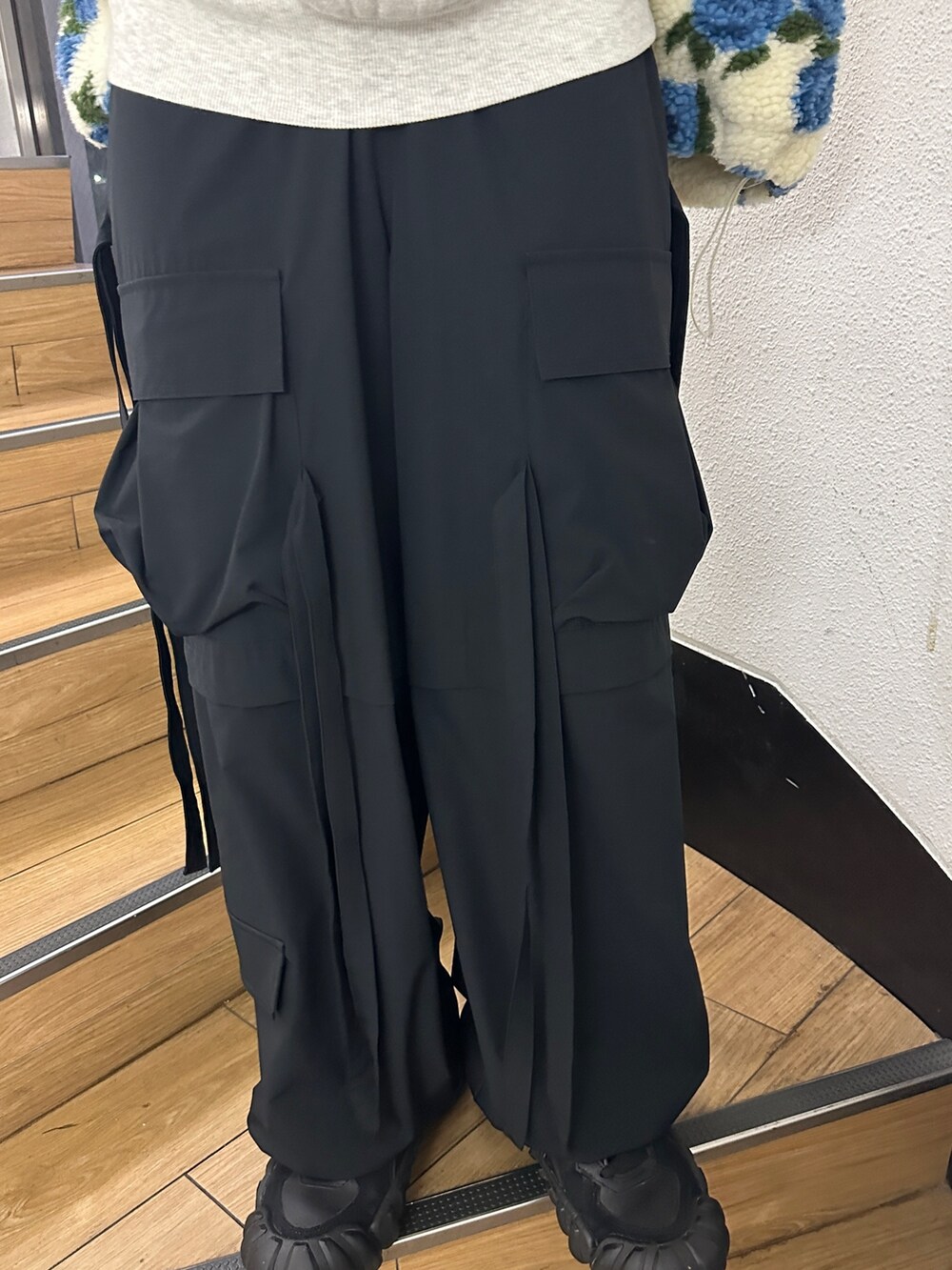 ホワイト系のブルゾン、グレー系のパーカー、ブラック系のその他パンツを着用したレディースの秋コーディネートの7枚目の写真