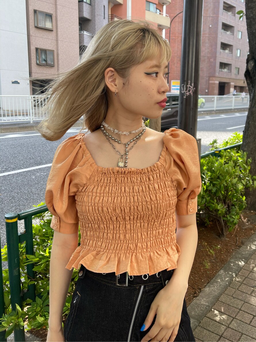 オレンジ系のシャツ/ブラウス、ブラック系のデニムパンツ、ブラック系のハットを着用したレディースの春コーディネートの5枚目の写真