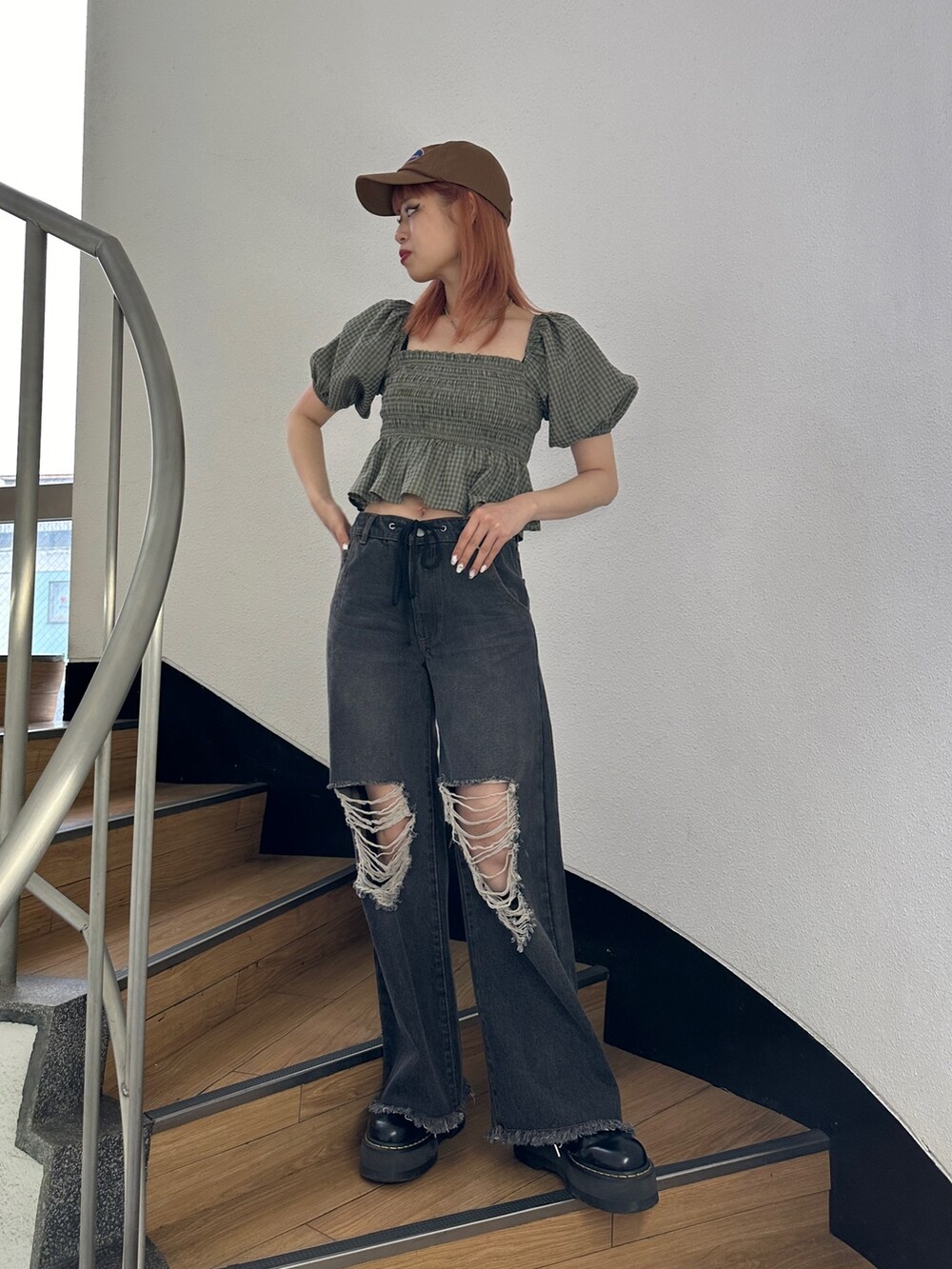 ブラック系のデニムパンツ、グリーン系のシャツ/ブラウス、ブラック系のブーツを着用したレディースの冬コーディネートの2枚目の写真